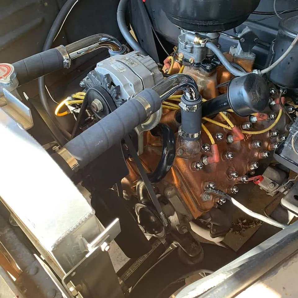 Mains d’un mécanicien intervenant avec une clé sur le moteur d’une voiture ancienne