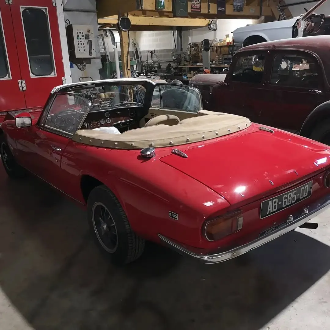 Cabriolet ancien rouge terminé, vu de trois quarts arrière dans l’atelier