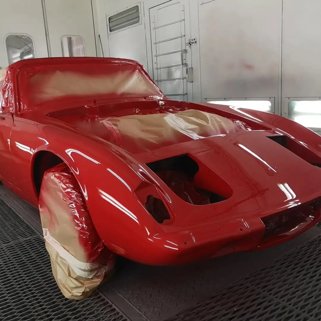 Avant d’un coupé ancien rouge fraîchement peint et masqué dans une cabine