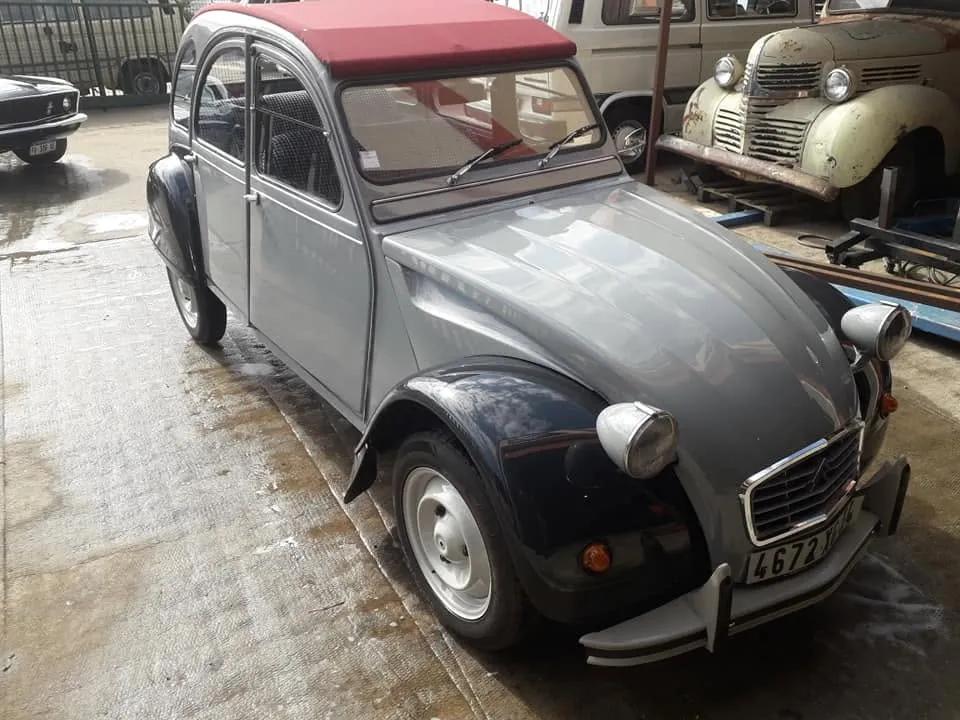 Citroën 2 CV bicolore grise aux ailes foncées, vue de trois quarts avant