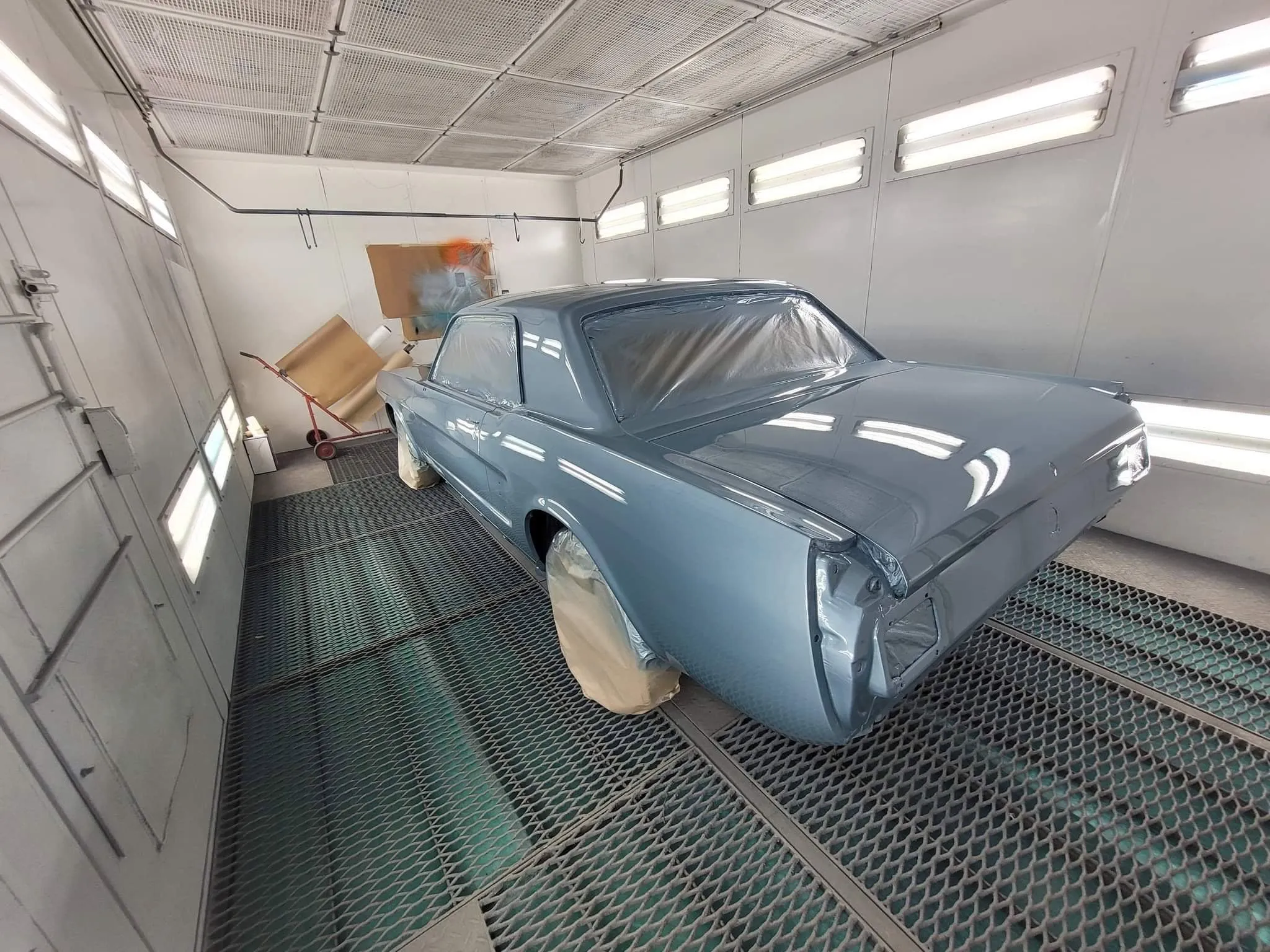 Mustang ancienne bleu clair fraîchement peinte et masquée dans une cabine